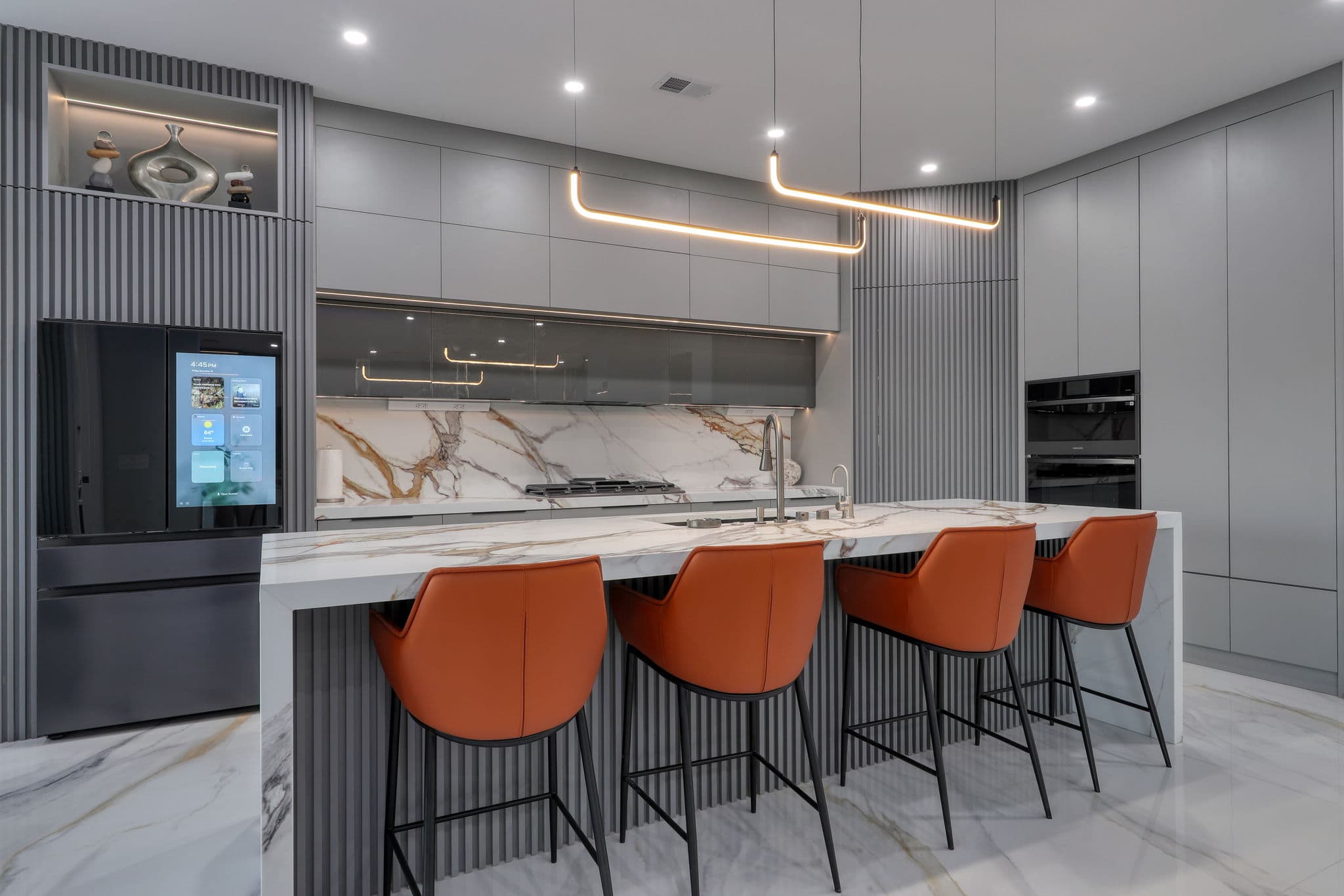 Modern Kitchen with Marble Backsplash and Custom Cabinetry and Concealed Slatted Pantry Door.