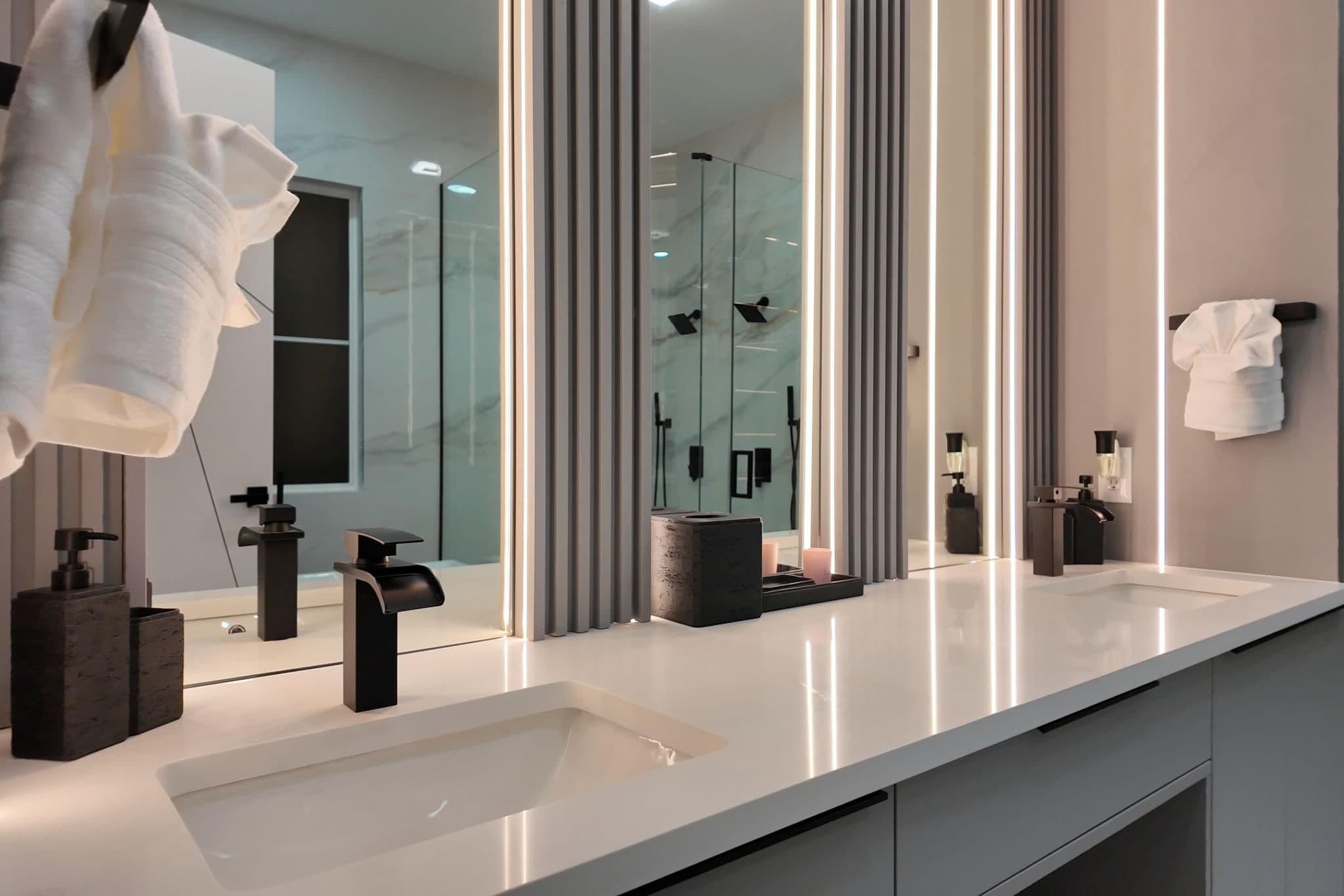 A double-vanity with backlit fluting.